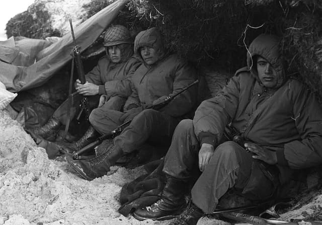 Tres soldados de las tropas argentinas con rifles FAL en un refugio improvisado. Foto: Archivo Telam